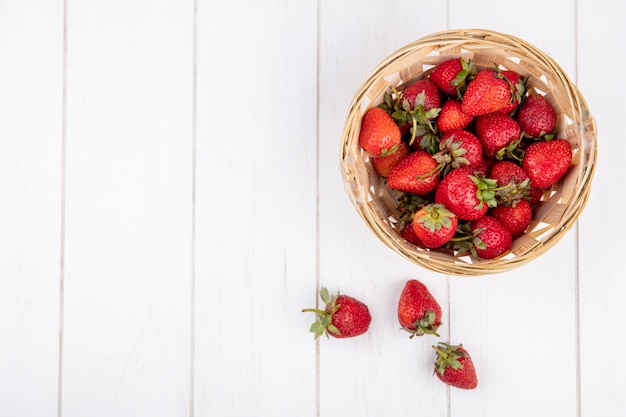 Top view of strawberries in basket on wooden surface