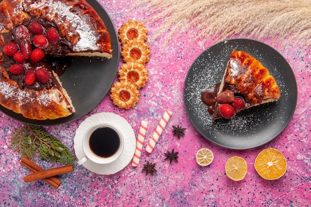 Top view strawberry chocolate cake with   and cup of tea on pink surface