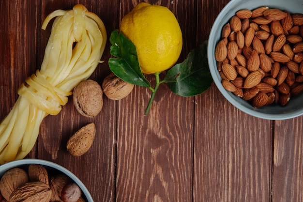 Vista dall'alto di formaggio a pasta filata con limone e mandorle in una ciotola blu su rustico