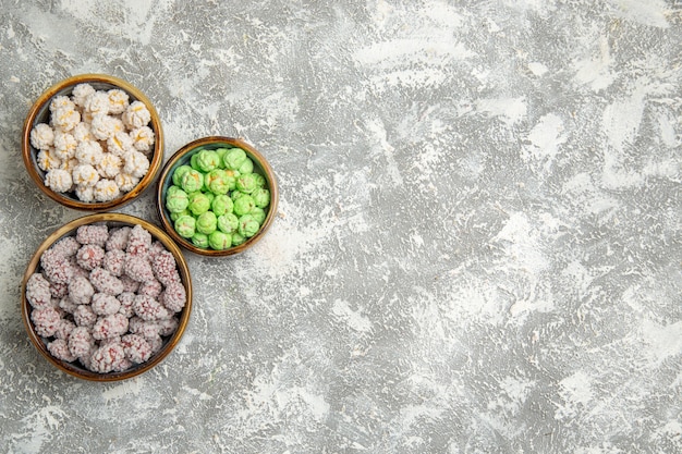 Top view sugar candies inside little plates on a white background candy sugar sweet cookie biscuit