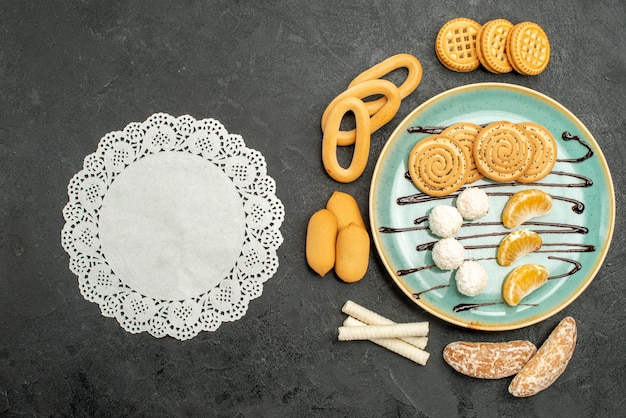 灰色の背景にビスケットとキャンディーとトップビューのシュガークッキー