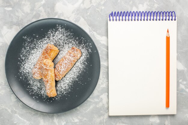白い表面にメモ帳が付いている砂糖粉ベーグルの上面図