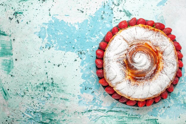 Top view sugar powdered cake with fresh red strawberries on the light blue surface