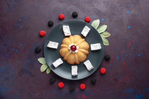 Free photo top view of sugar powdered candies delicious nougat with cake and confiture berries on dark surface