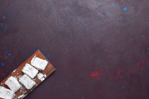 Top view of sugar powdered candies nougat on the dark surface