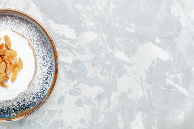 Top view sugar powdered raisins dried grapes inside plate on white desk