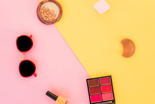 Top view of sunglasses and beauty products on dual background