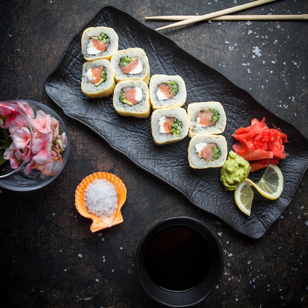 暗い皿に生姜の漬物とわさびと醤油と箸でトップビュー寿司セット