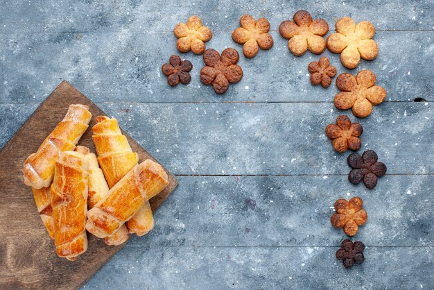 Top view sweet bangles with cookies on the grey background sweet bake pastry cake sugar biscuit