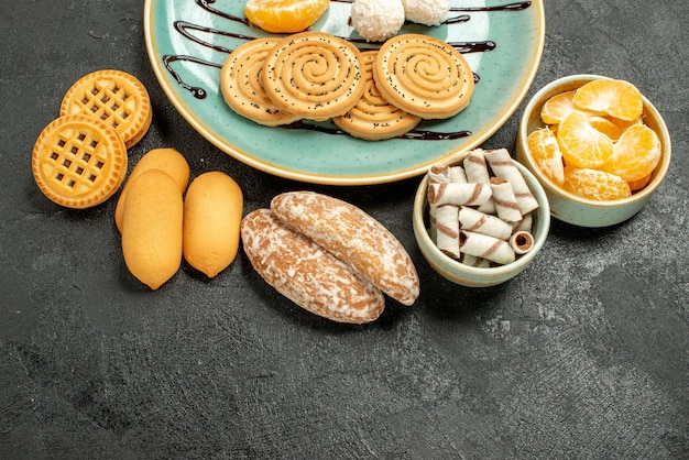 Top view sweet biscuits with coconut candies on grey background