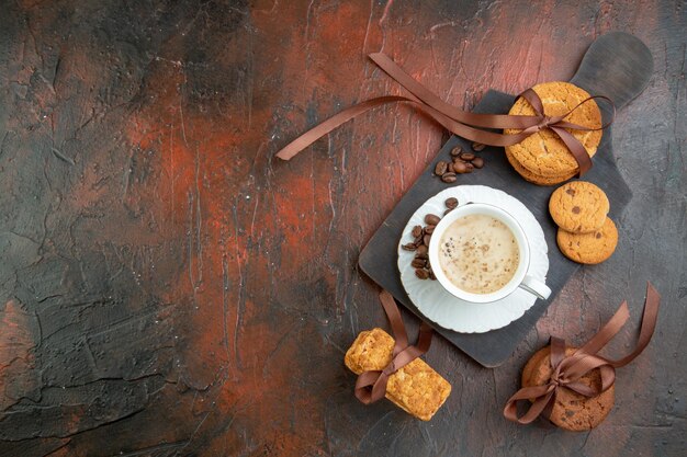 Top view sweet biscuits with cup of coffee on dark brown background tea cake couple color morning love cookie sweet