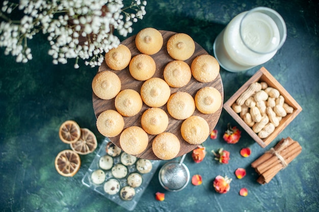 Vista dall'alto biscotti dolci con noci e latte su sfondo blu scuro torta biscotto tè dessert biscotto torta di zucchero