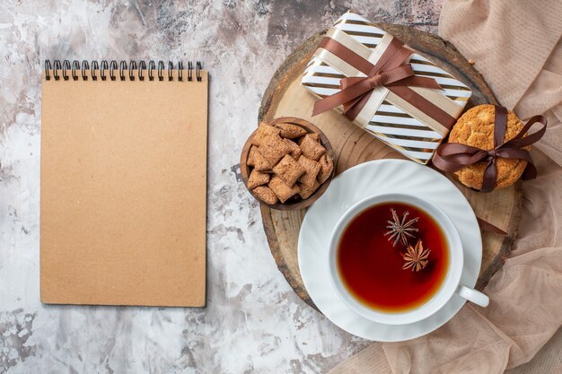 Top view sweet biscuits with present and cup of tea on light table