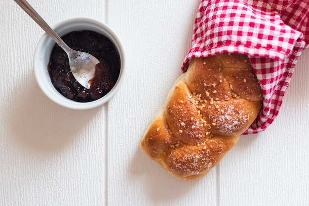 Top view of sweet bread and jam on wooden table