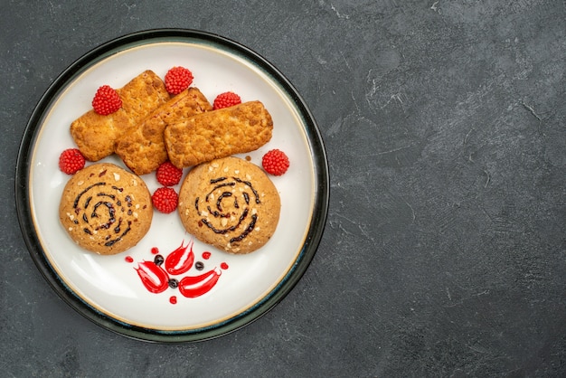 トップビュー甘いクッキー灰色の机の上のお茶のためのおいしいお菓子クッキー砂糖甘いビスケットケーキ