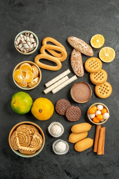 Top view sweet cookies with biscuits and candies on grey background