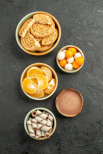 Foto gratuita vista dall'alto biscotti dolci con caramelle su sfondo grigio scuro