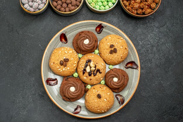 Top view sweet cookies with candies on grey background sugar cookie sweet biscuit cake tea