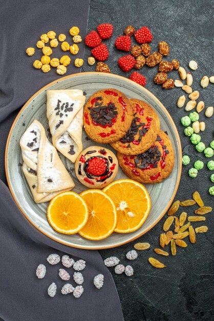 Top view sweet cookies with pastries and orange on grey surface fruit cookie biscuit sweet