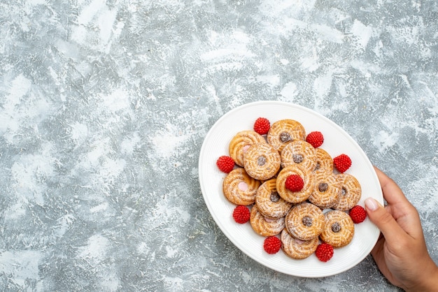 Top view sweet cookies with raspberry confitures inside plate on white background cookie sugar biscuit sweet cake tea