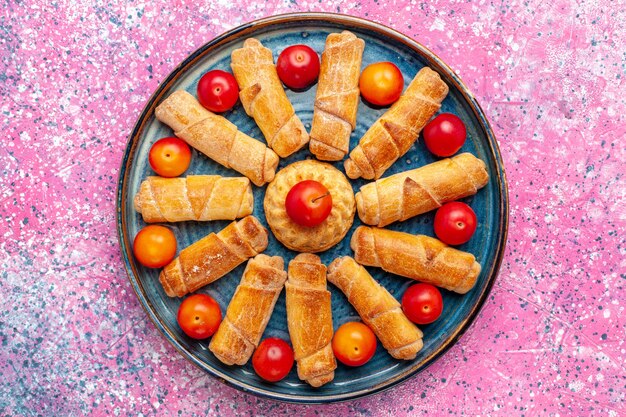 Top view sweet delicious bagels baked pastry inside tray on pink desk