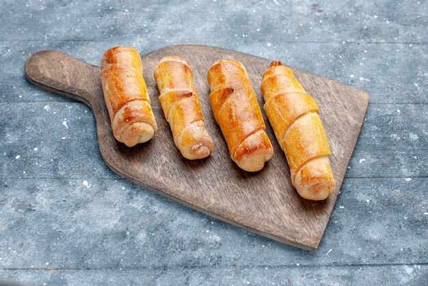 Top view sweet delicious bangles with filling on the grey wooden desk sweet sugar bake pastry