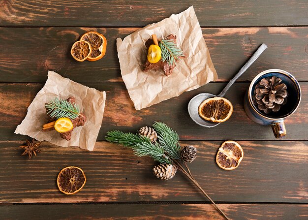 Top view of sweet desserts with pine cones and dried citrus