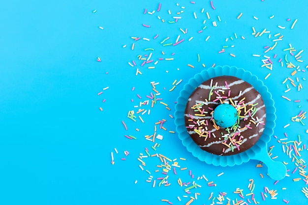 Free photo a top view sweet donuts delicious and chocolate based along with candies on blue desk, candy cake biscuit color