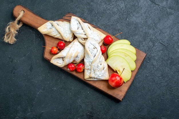 Vista dall'alto dolci fruttati dolci con frutta fresca sulla superficie grigio scuro torta di zucchero dolce biscotto di frutta