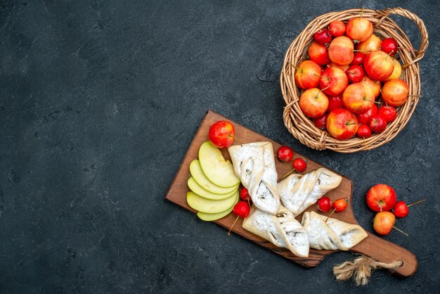 Top view sweet fruity pastries with fresh fruits on dark-grey surface fruit biscuit sweet sugar