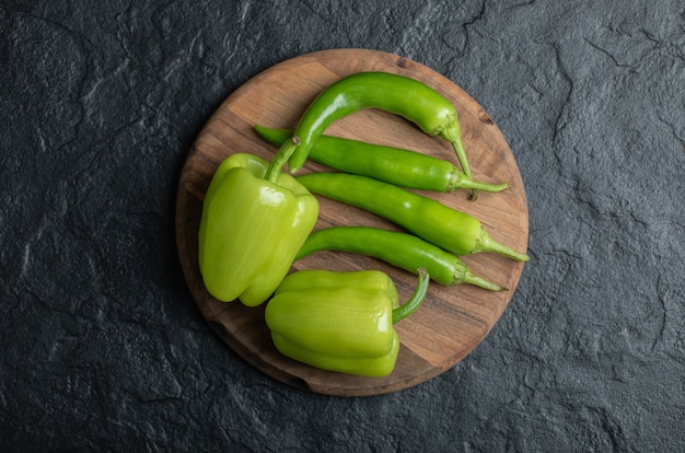 Top view of sweet and hot peppers on wooden board