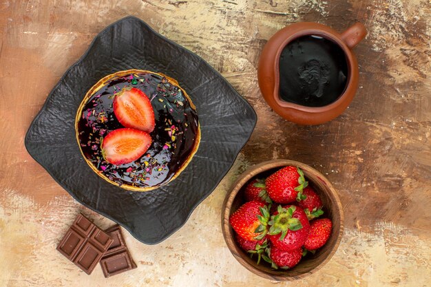 Top view sweet pancakes with strawberries on wooden desk