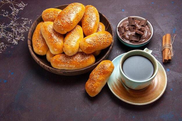 暗い背景のペストリー生地の食事食品パティティーにお茶とチョコレートのカップと甘いパテの上面図