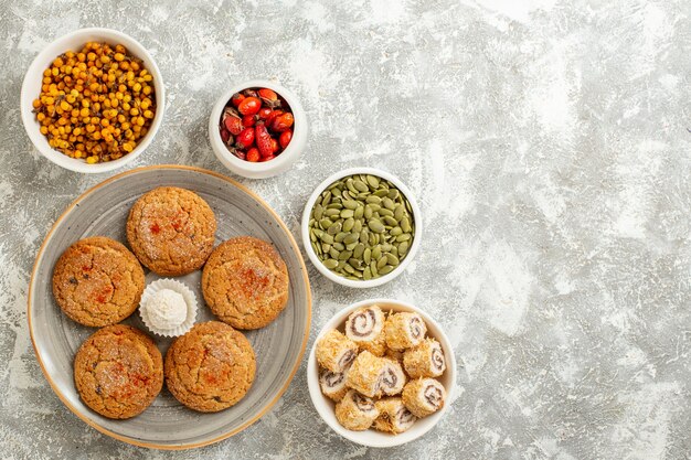 Top view sweet sand cookies with fruits and seeds on white background