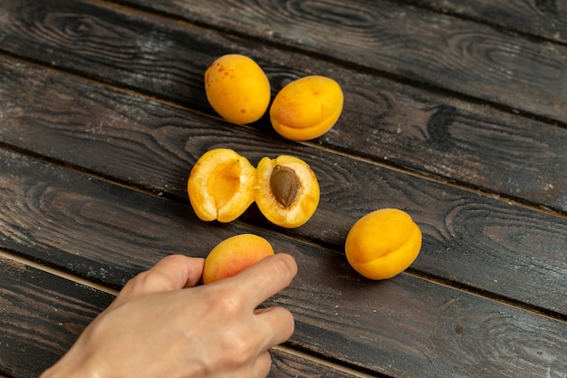 Вид сверху сладких желтых абрикосов, спелых и свежих фруктов на коричневом деревенском фоне свежести закуски