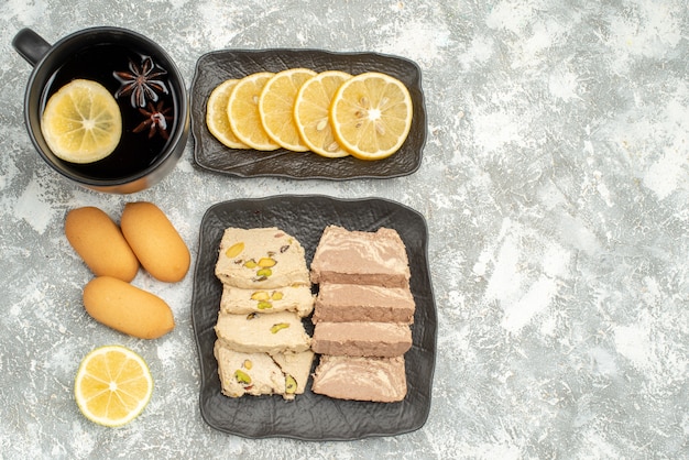 Top view sweets a cup of tea cookies lemon sunflower seed halva