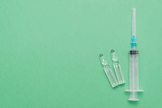 Top view syringe on green background