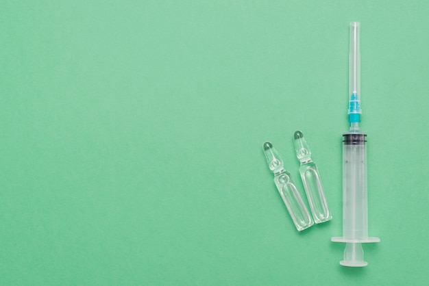 Top view syringe on green background