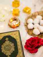 Free photo top view table arrangement with quran, roses and pastries