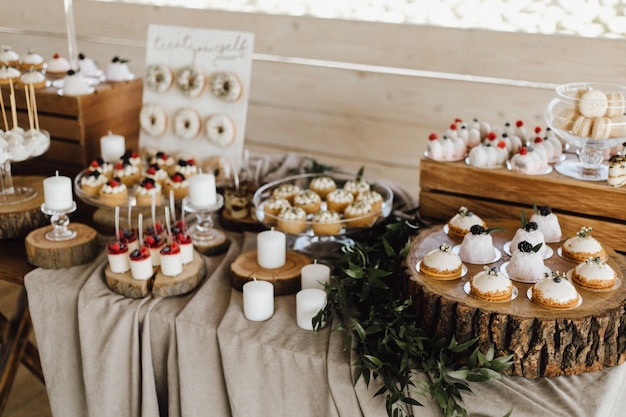 Top view of table full of sweet delicious desserts, cupcakes, donuts and panna cotta desserts