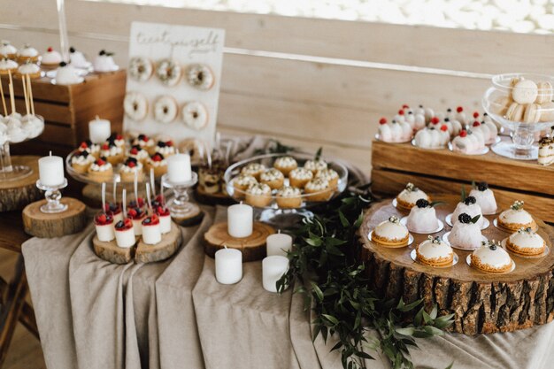 Вид сверху на стол, полный сладких вкусных десертов, кексов, пончиков и десертов Панна Котта
