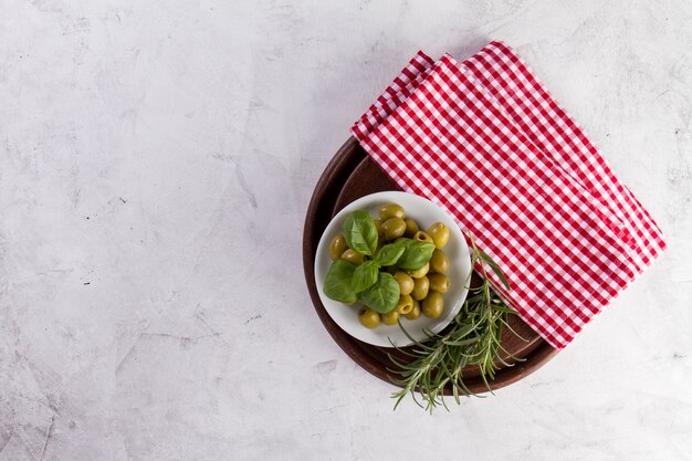 Top view of tablecloth, olives and rosemary