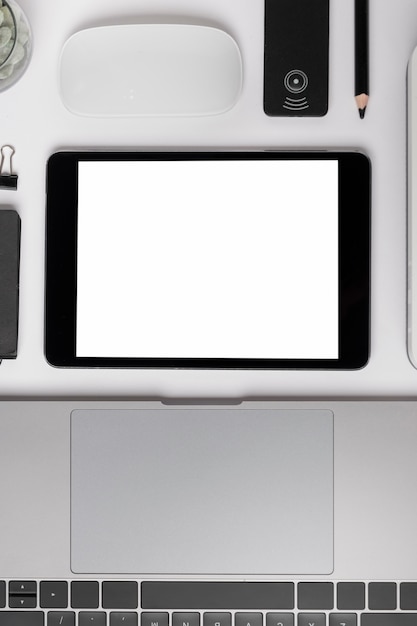 Top view tablet near laptop mock-up