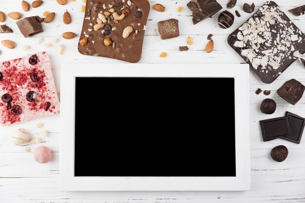 Top view tablet surrounded by chocolate