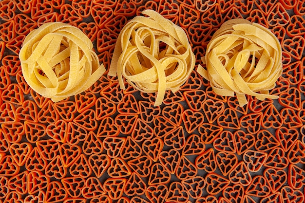 Free photo top view tagliatelle pasta on heart shaped italian pasta