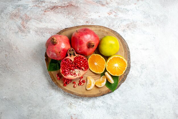 Top view tangerines and pomegranates fresh mellow fruits on white background fruit trees color health fresh