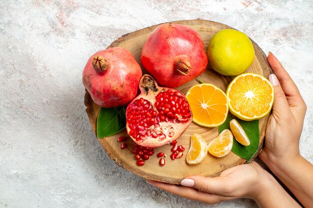 Вид сверху мандарины и гранаты свежие спелые фрукты на белом фоне фруктовое дерево здоровье свежая витаминная еда