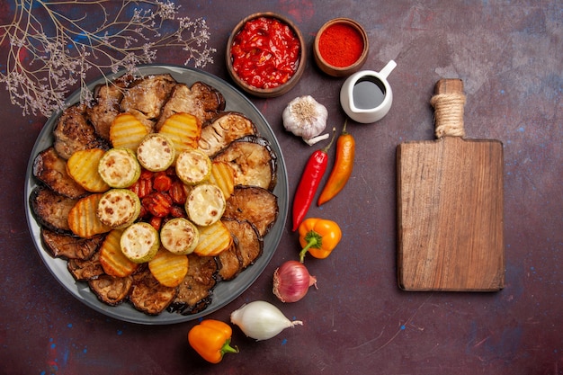 Top view tasty baked vegetables potatoes and eggplants on the dark background meal oven cooking bake vegetable