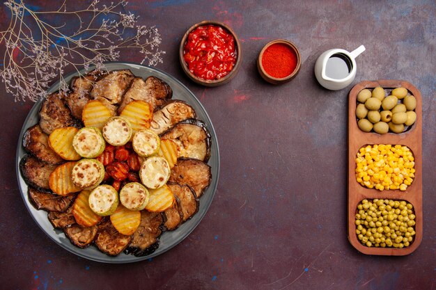 Top view tasty baked vegetables potatoes and eggplants on a dark background meal oven cooking bake vegetables