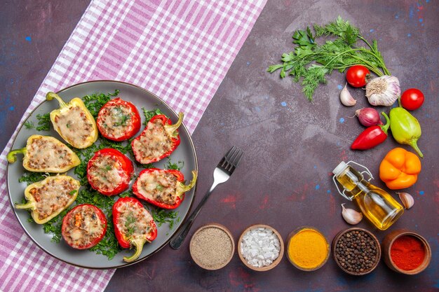 Top view tasty bell-peppers delicious cooked meal with meat and greens on dark floor dinner meal food dish pepper spicy